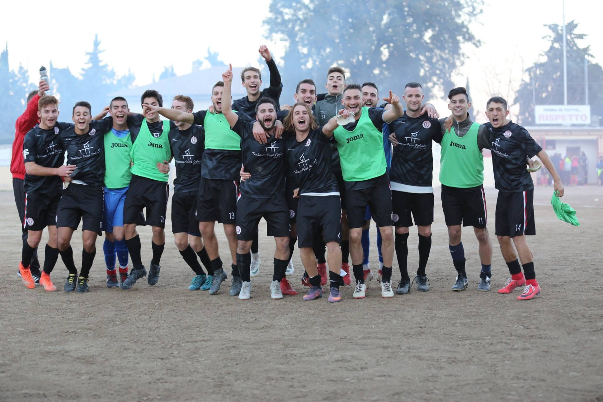 La squadra dell'Union Fossacesia festeggia in campo insieme, con fumo colorato sullo sfondo