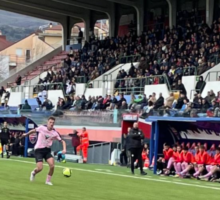 Un giocatore in maglia rosa in azione durante una partita allo stadio